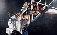 Due giocatori di basket vanno a rimbalzo durante un incontro di pallacanestro.