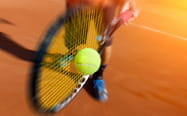 Un giocatore di tennis impegnato su un campo di terra rossa