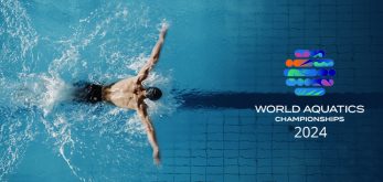 atleta nuota in piscina olimpionica con logo dei world acquatics championsips 2024